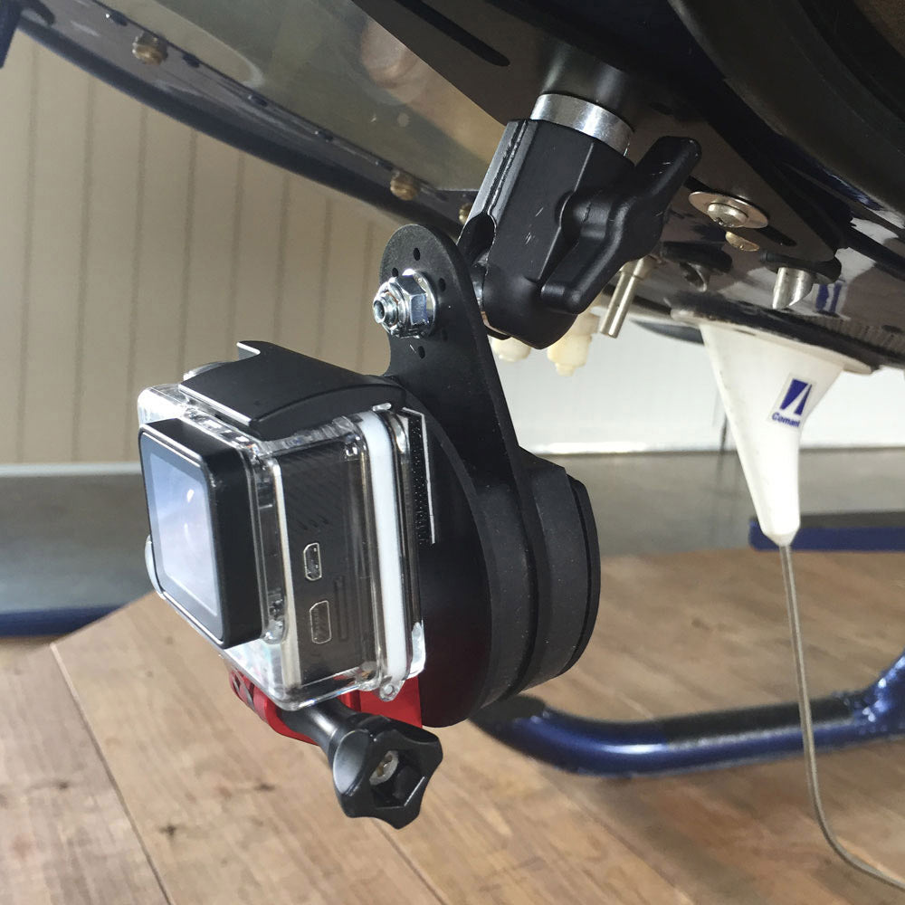 GoPro action camera in clear housing mounted with Rock Steady VibeX Ball Mount system on underside of vehicle or machinery, showing articulated joints and red tightening knob