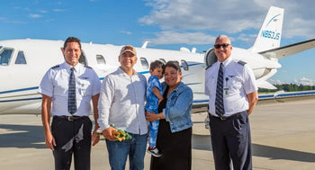 AeroAngel crew and family beside a private jet, providing life-saving flights for children.
