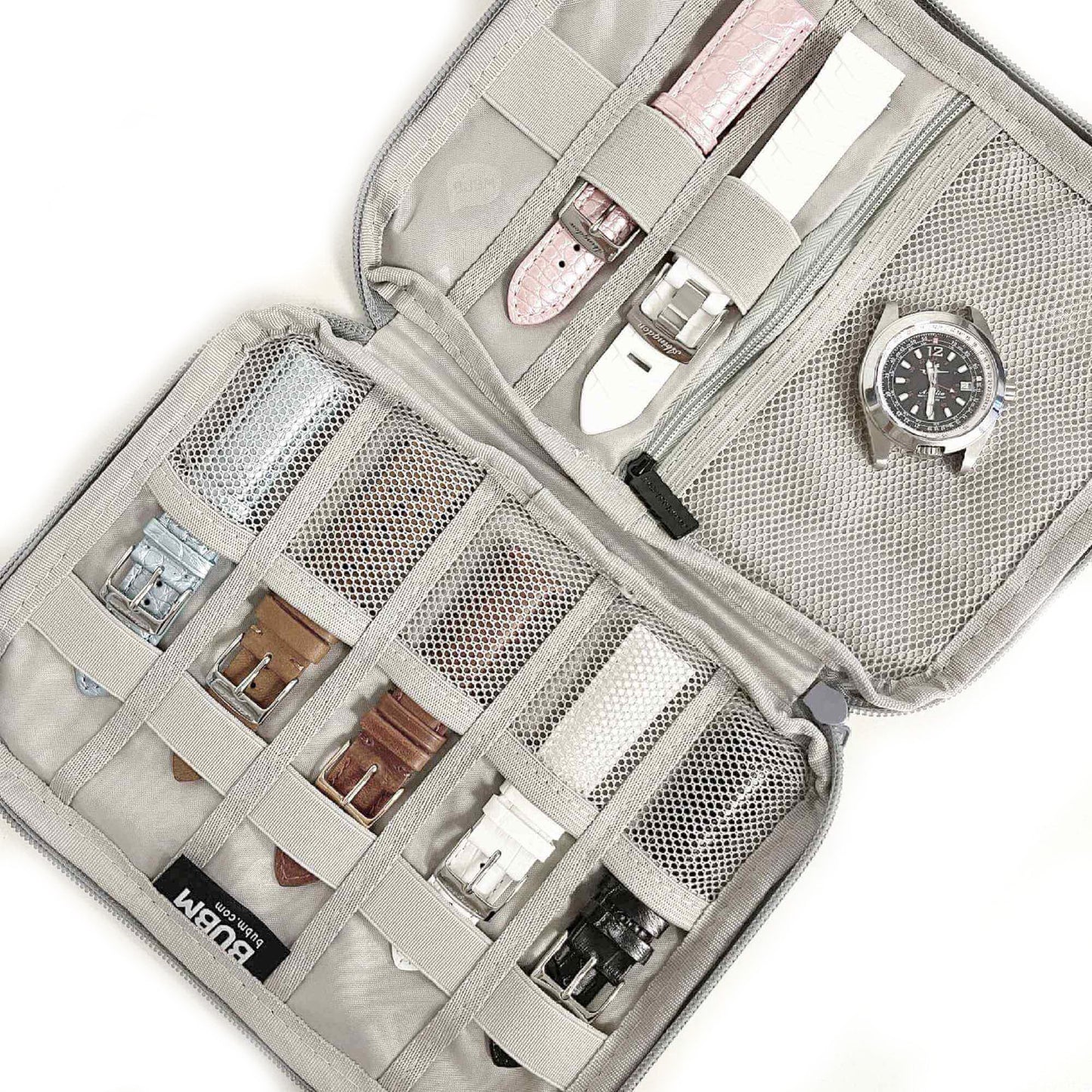 Open travel watch and strap organizer pouch showing multiple watch straps and a timepiece stored securely.