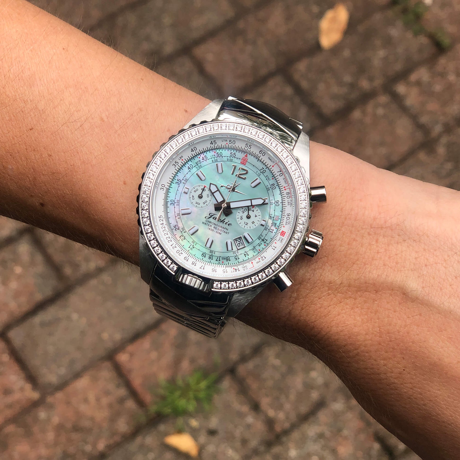 Jackie Seaplane Green Women’s Pilot Watch with Mother-of-Pearl Dial and Stainless Steel Band Shown on Wrist Outdoors”