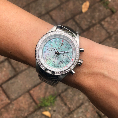 Jackie Seaplane Green Women’s Pilot Watch with Mother-of-Pearl Dial and Stainless Steel Band Shown on Wrist Outdoors”