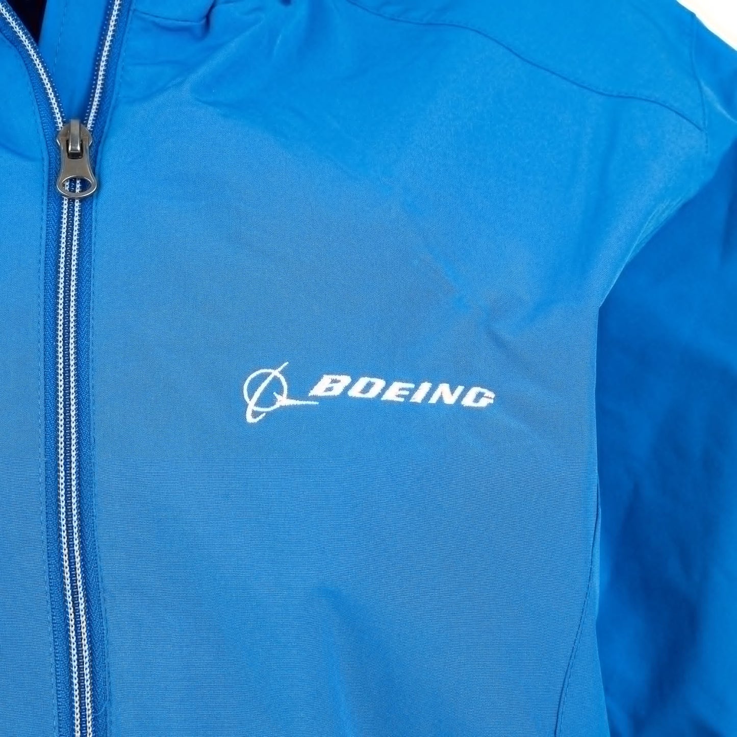 Detail view of royal blue Ladies Boeing jacket embroidered Boeing logo on chest
