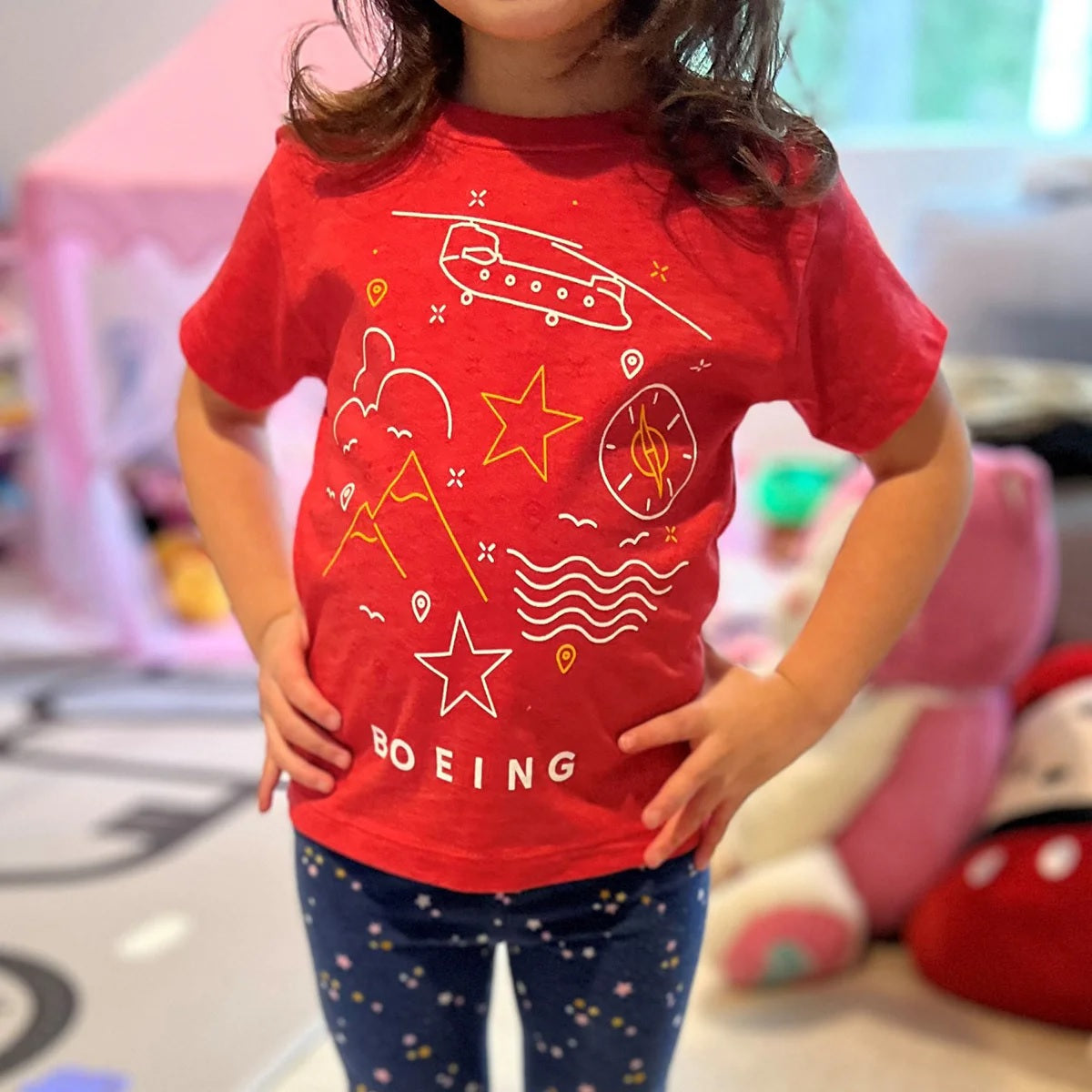 Child modeling Boeing Defense Doodle toddler t-shirt featuring colorful aerospace-inspired graphics