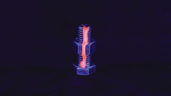 Dykem Cross Check FAST Orange applied on fastener, glowing under UV light
