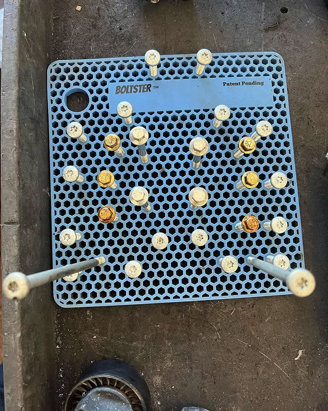 Light blue Boltster Original Organizer holding mixed-length bolts in a precise configuration, displayed on a metal work surface.