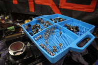 Boltster™ Flexible Organizing Tray in blue filled with assorted bolts and fasteners during engine assembly