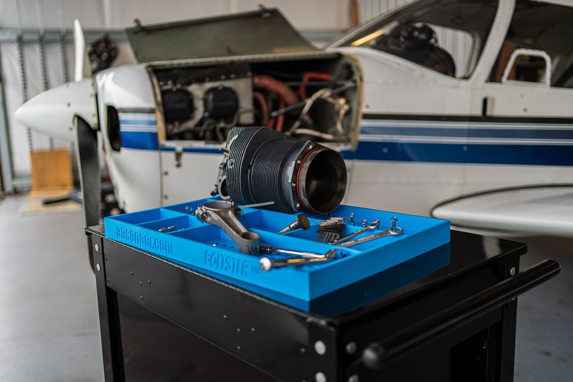 Boltster™ Top Box Tool Tray in blue used during aircraft engine maintenance, organized with tools and components on a black tool cart