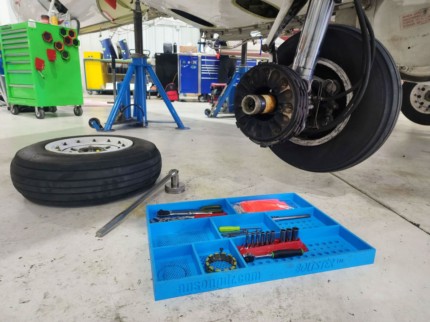 Boltster™ Top Box Tool Tray in blue used during aircraft wheel maintenance, holding tools, sockets, and fasteners in an organized layout