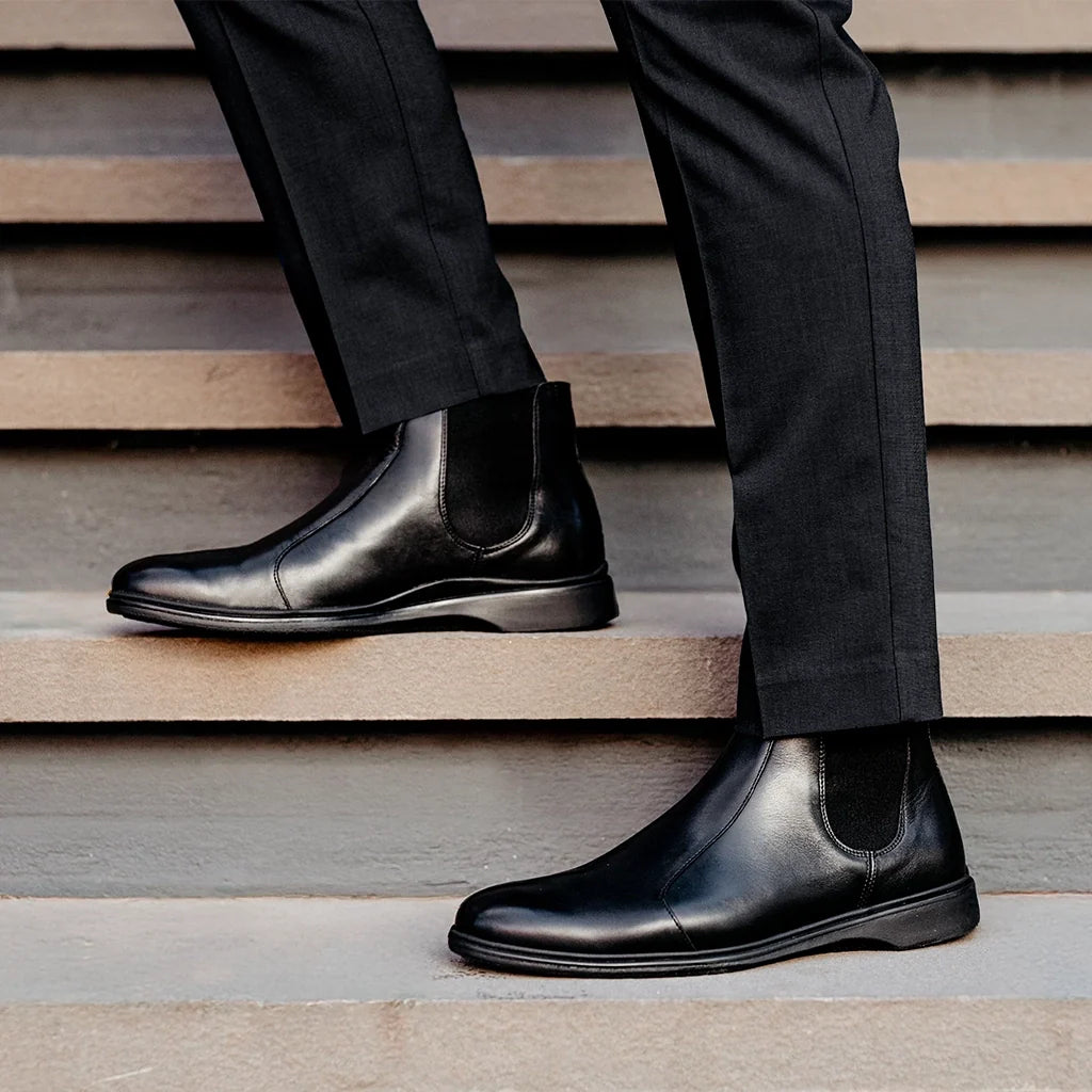 Amberjack Chelsea Obsidian black pilot boot, left side view, elastic side gore slip-on construction | Lifestyle sstanding on steps