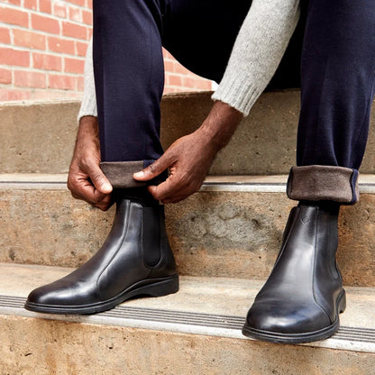 Amberjack Chelsea Obsidian black pilot boot, left side view, elastic side gore slip-on construction | Lifestyle Sitting on Steps