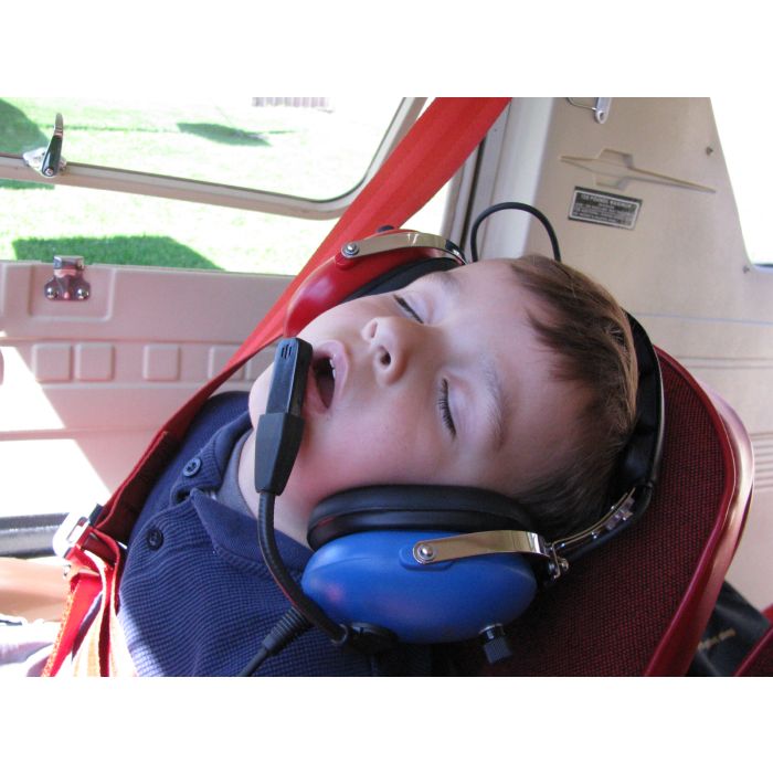 Young Boy Sleeping in Cockpit Wearing Pilot USA PA‑1151ACB Red and Blue Youth Aviation Headset