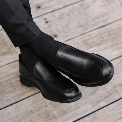 Amberjack Slip-On Obsidian black pilot dress shoe, left side view, laceless aviation shoe  | Lifestlye legs crossed