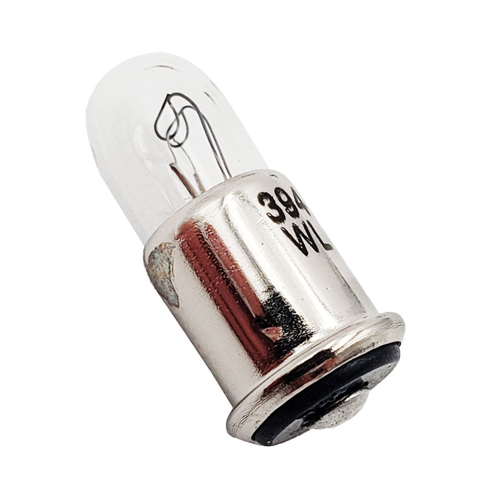 Close-up of Wamco 394 subminiature aircraft lamp showing clear T-1 3/4 bulb and midget flange base stamped ‘394 WL’