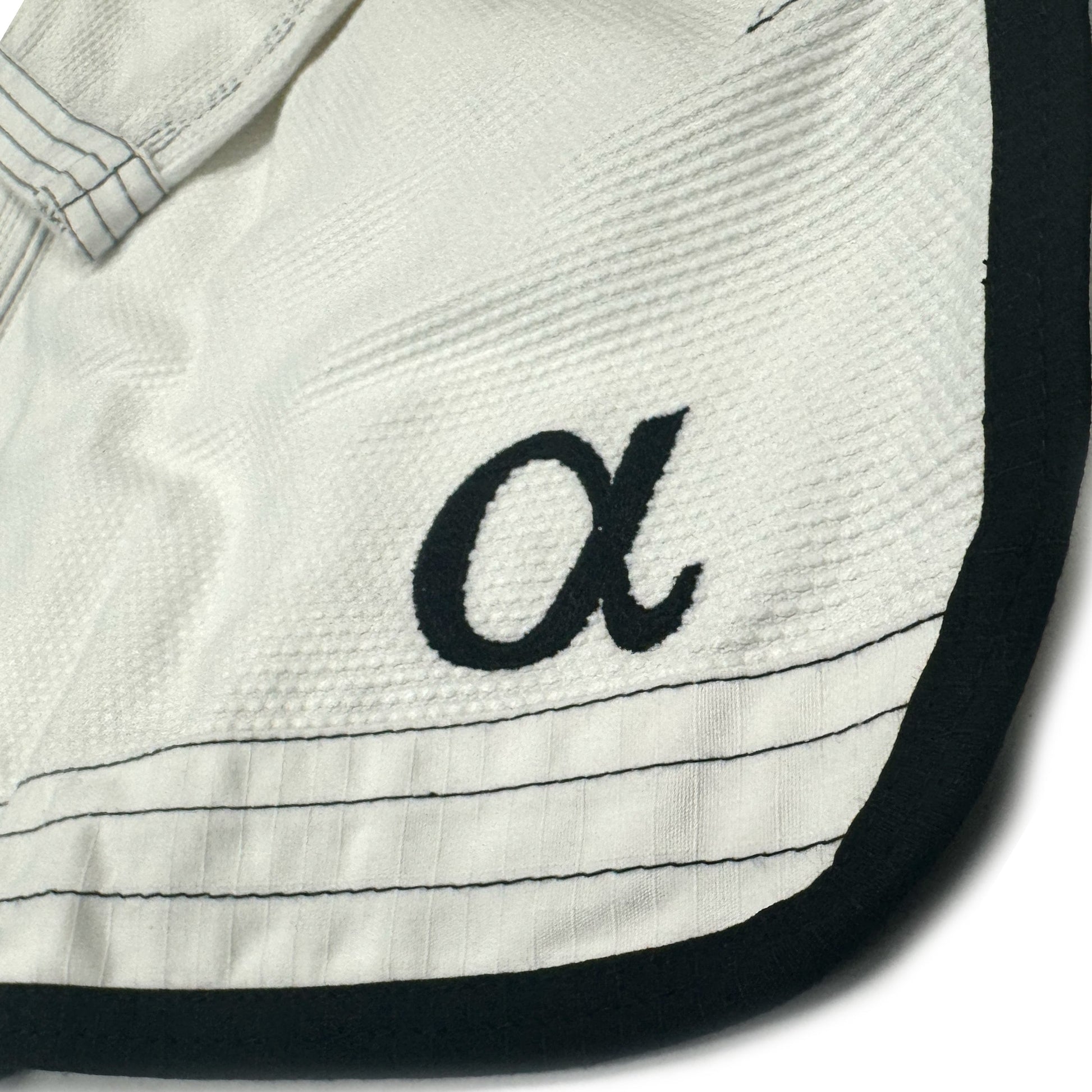 Zed Honra Women’s Alpha Gi – Close-Up of Greek Letter Alpha and Reinforced Edge Stitching on White BJJ Kimono