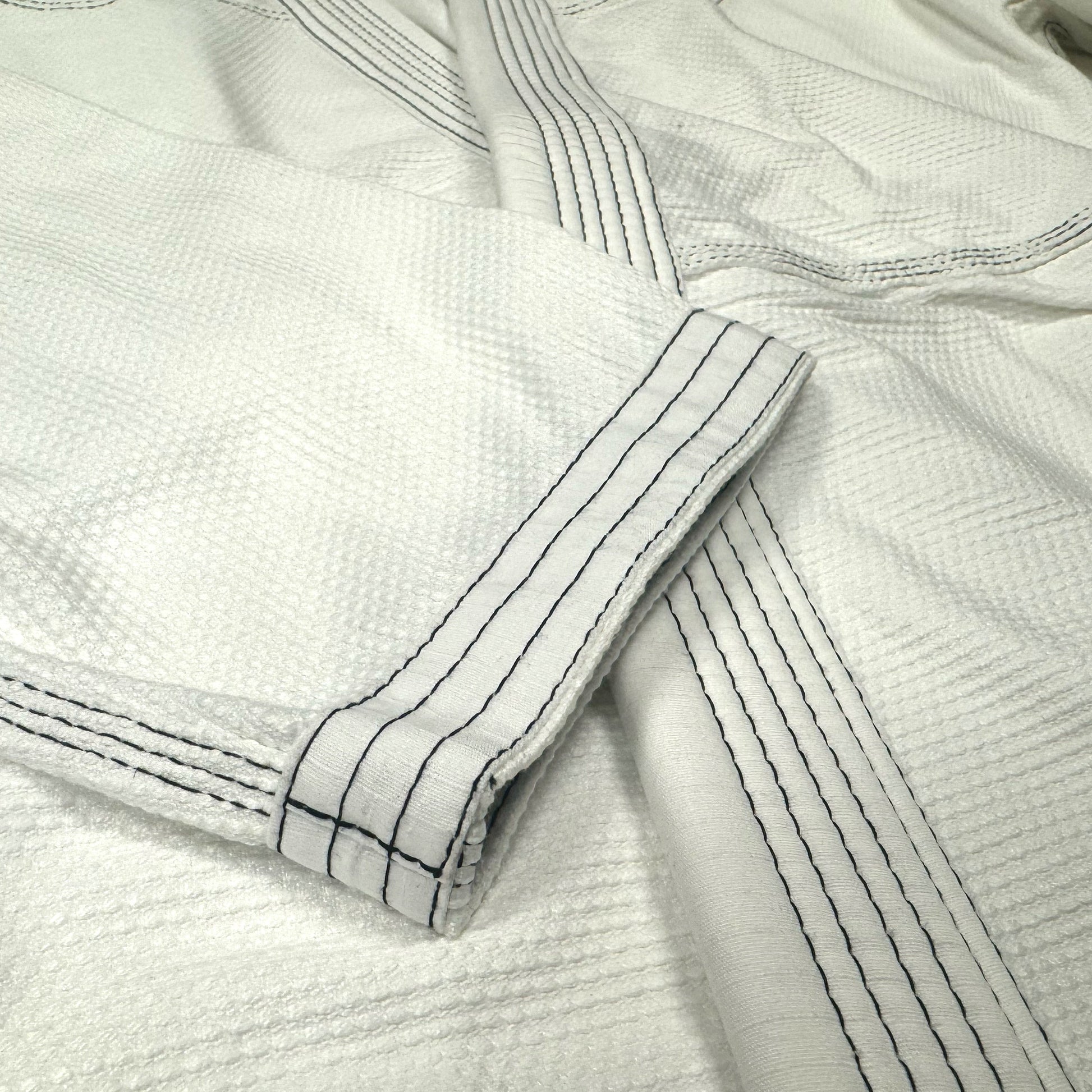 Zed Honra Women’s Alpha Gi – Close-Up of White BJJ Kimono Sleeve with Reinforced Stitching