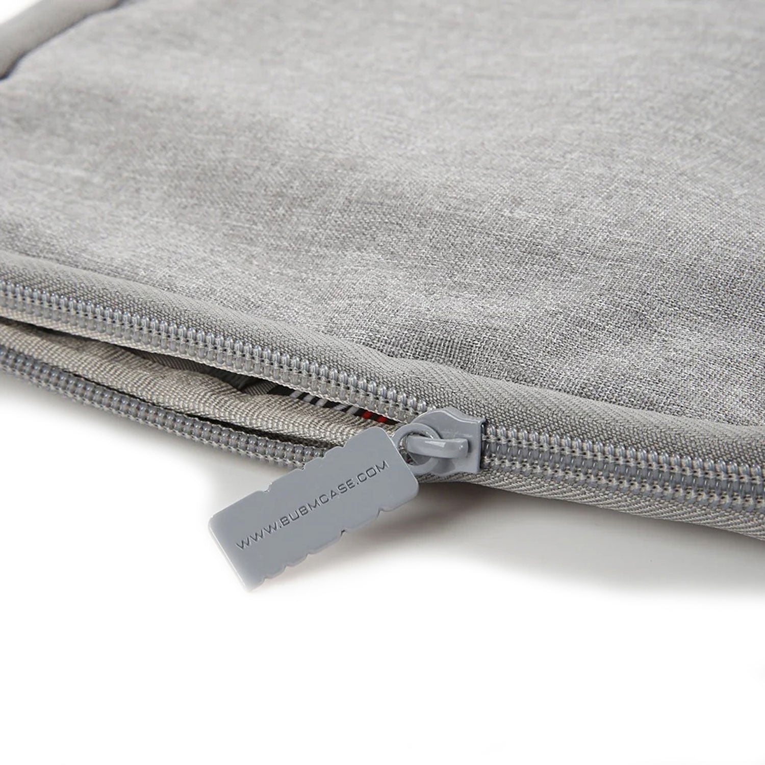 Close-up of durable zipper with branded pull tab on soft gray watch strap organizer pouch.