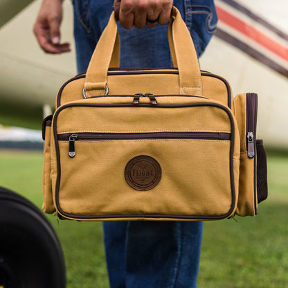 Detailed view of the man carrying the Flight Outfitters Bush Pilot Flight Bag, showing its leather handle and sturdy build.