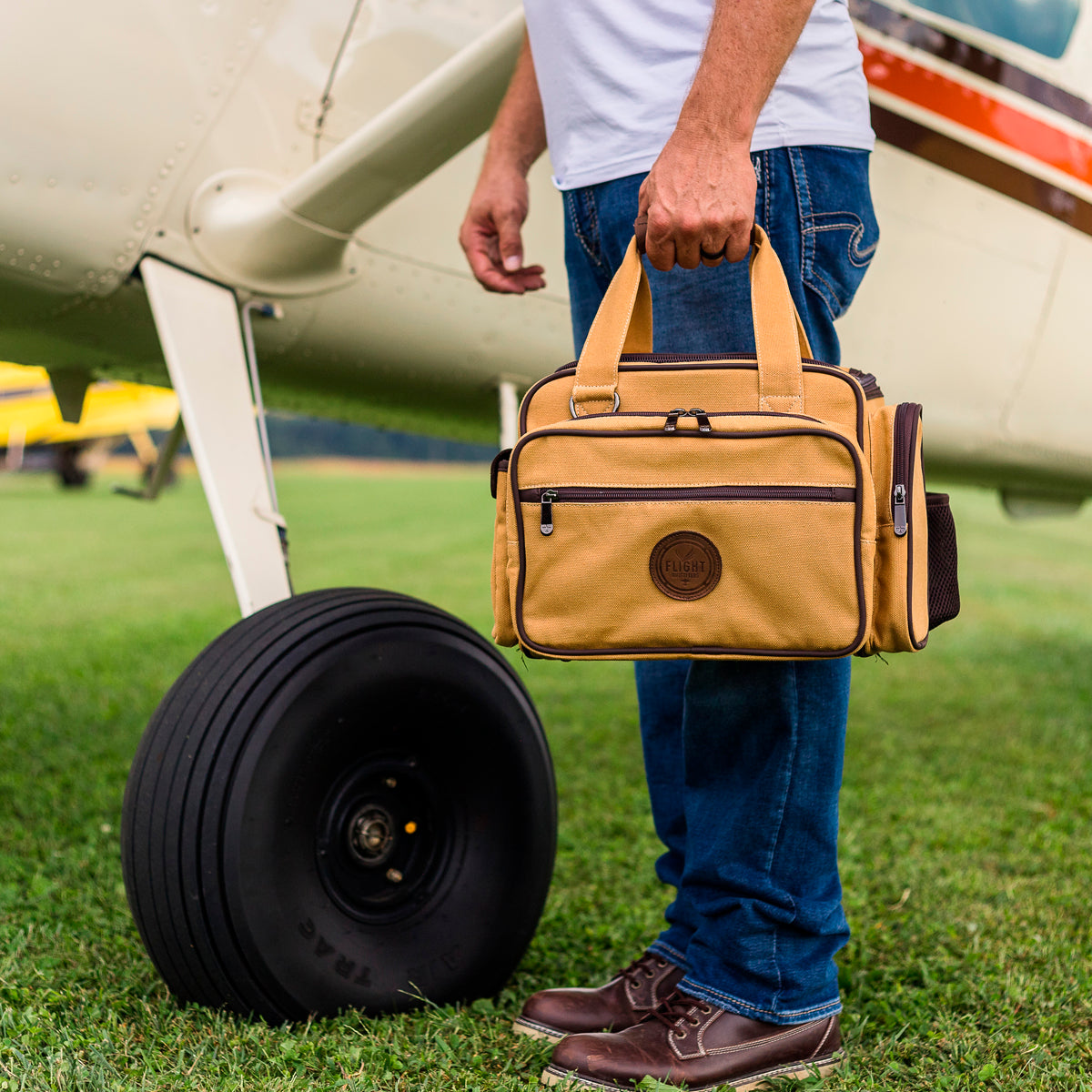 A man holding the Flight Outfitters Bush Pilot Flight Bag, emphasizing its portability and rugged style.