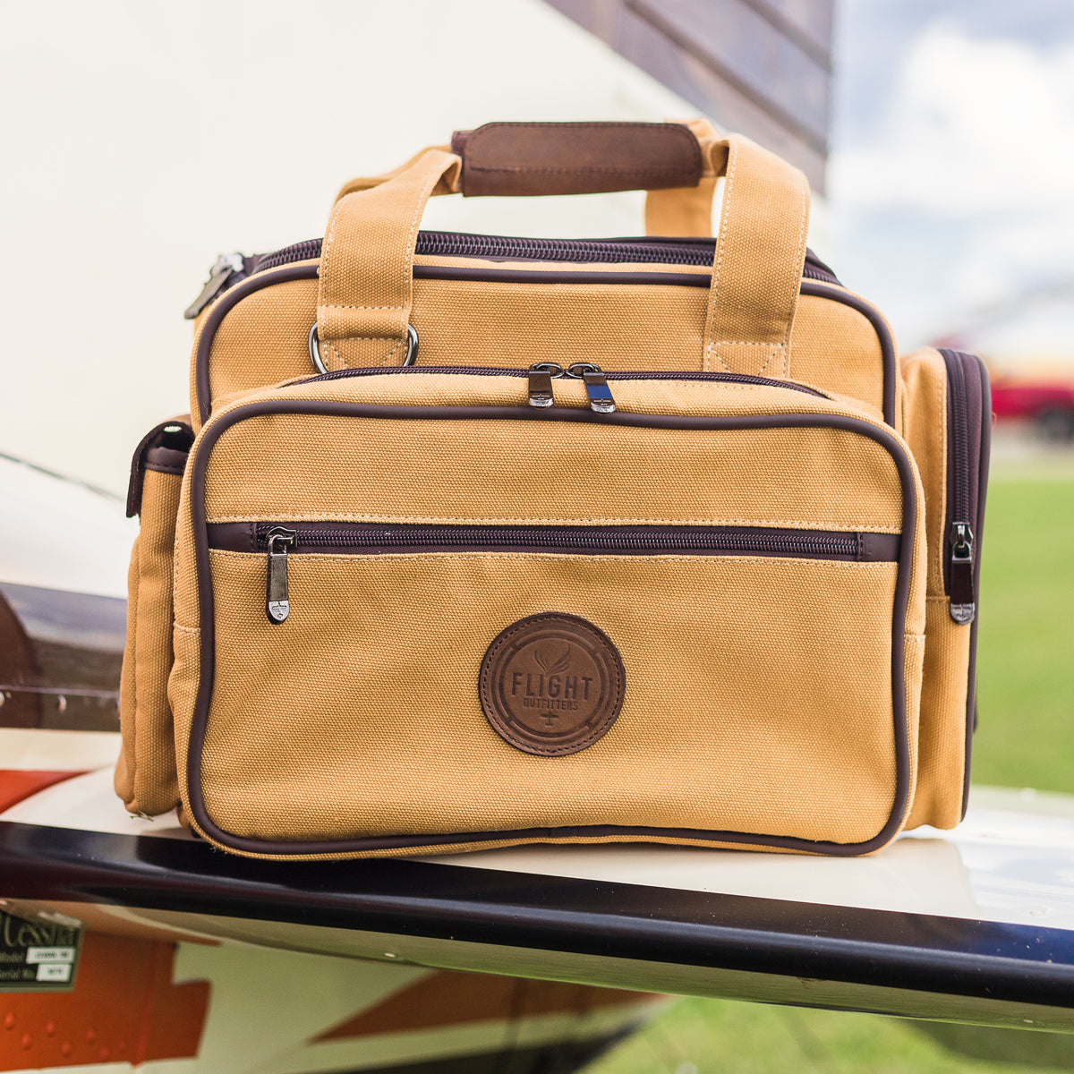Flight Outfitters Bush Pilot Flight Bag resting on the wing of an aircraft, demonstrating its aviation-centric design.