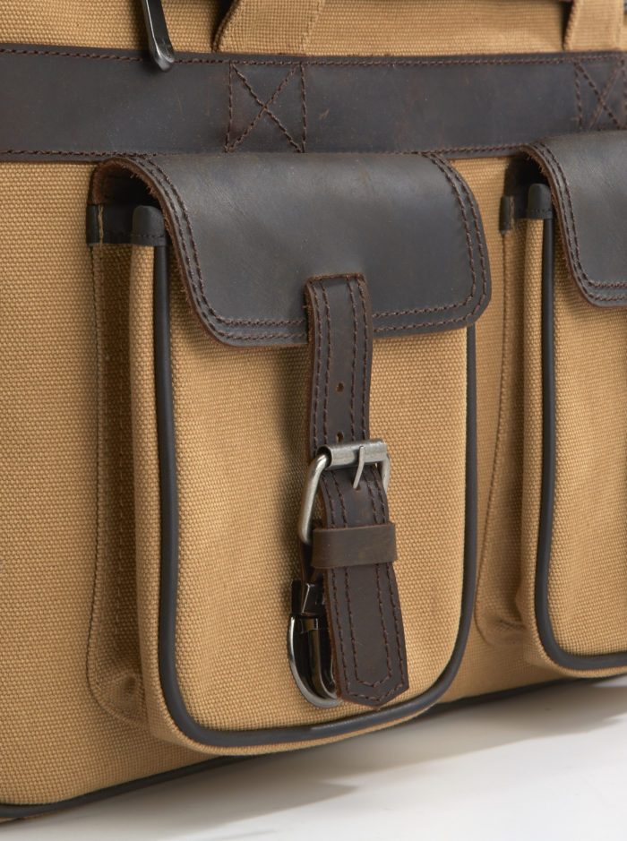 Close-up of the front organizer pocket of the bag, featuring compartments and durable metal hardware.