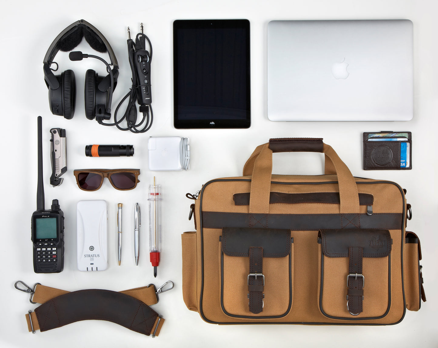 Flight Outfitters Bush Pilot Folio Bag surrounded by various items, highlighting its spacious capacity and organized storage.
