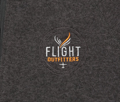 Close-up view of the Flight Outfitters logo on the Women's Fairbanks Fleece in Heather Obsidian, emphasizing branding details.