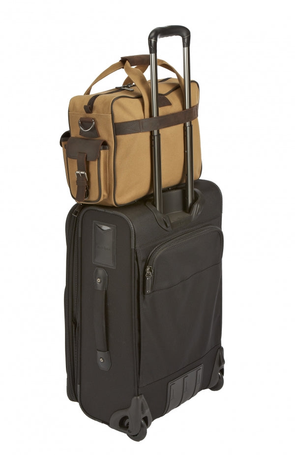 Flight Outfitters Bush Pilot Folio Bag securely attached to rolling luggage with its rear strap.