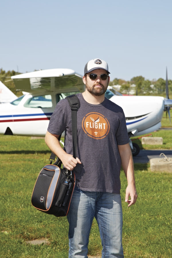 A man standing in front of an aircraft wearing the Flight Outfitters Women's Vintage V-Neck T-Shirt, showcasing its aviation-inspired aesthetic.
