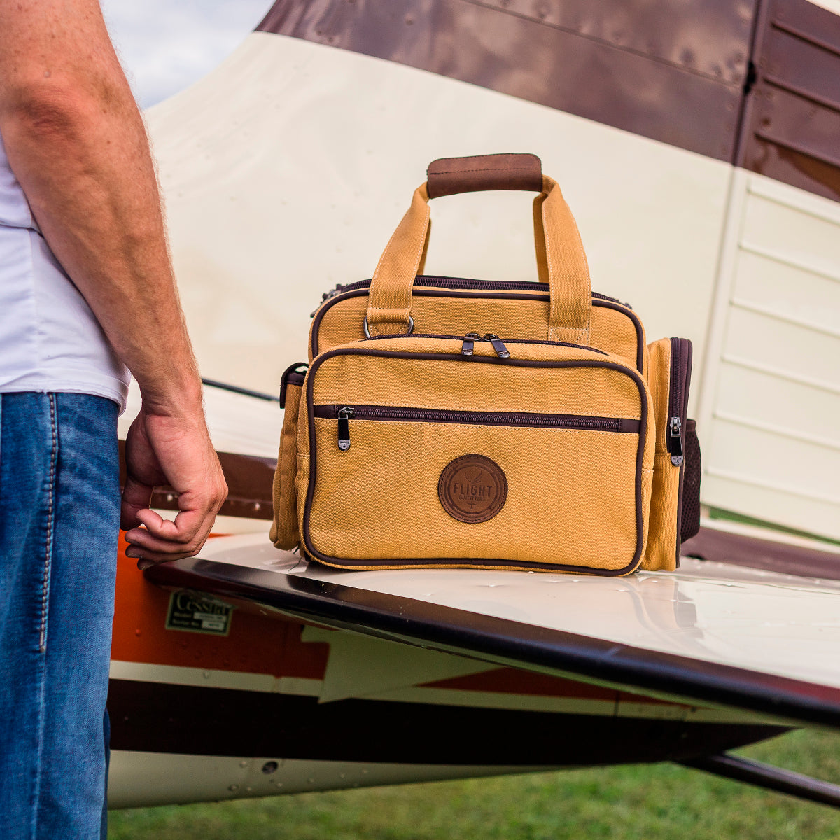 Flight Outfitters Bush Pilot Flight Bag resting on the wing of an aircraft, demonstrating its aviation-centric design.